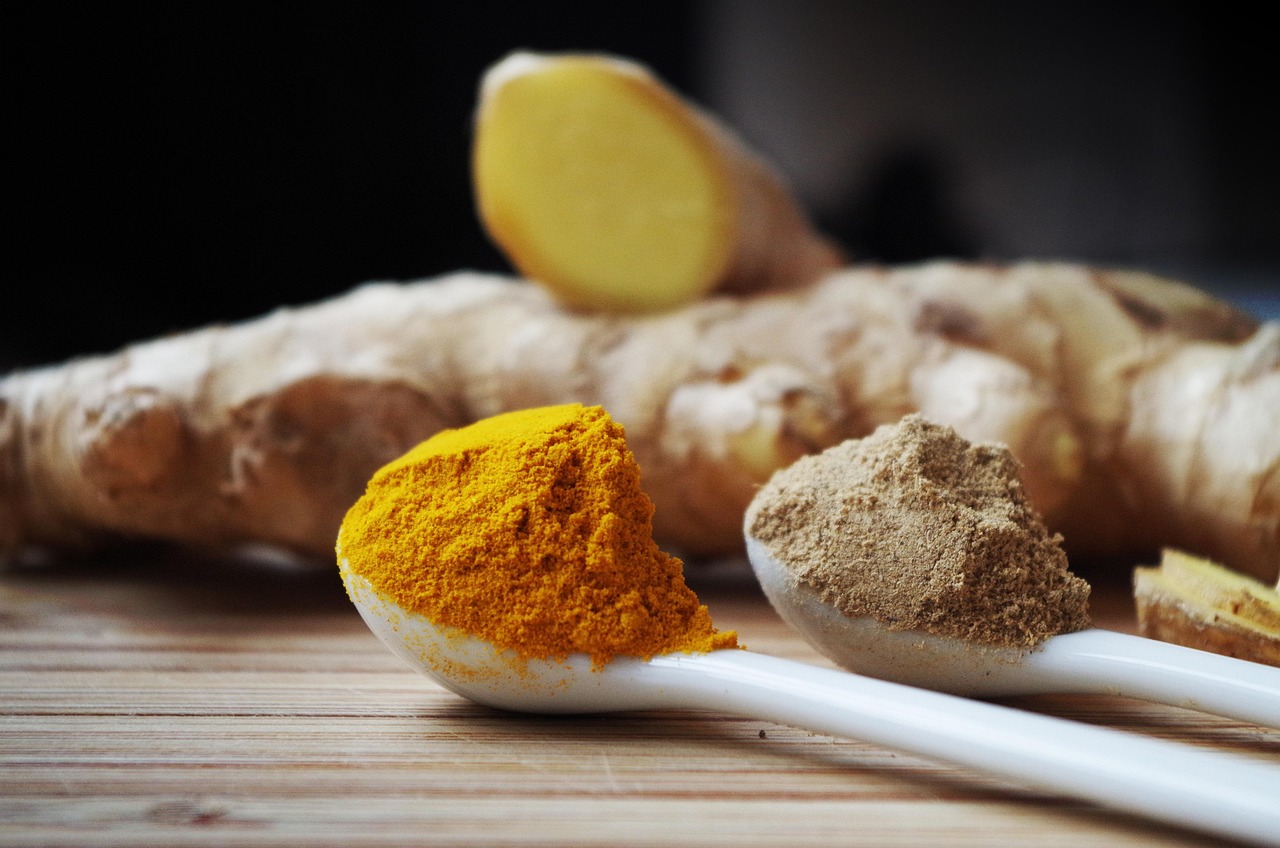 Curcuma fresca su un tavolo di legno, simbolo di proprietà antinfiammatorie per la salute intestinale.